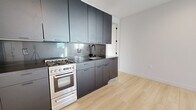 Located at 1412 1/2 Lucas Ave in Los Angeles, this thoughtfully designed one-bedroom, one-bathroom unit offers a clean, modern aesthetic throughout its efficiently arranged single-floor layout. Light wood flooring runs continuously through all rooms, creating a cohesive and airy feel.

The open living area is bathed in natural light from a large window and features recessed lighting, a wall-mounted mini-split system for climate control, and crisp white walls that amplify the sense of openness.

The kitchen is a standout feature, showcasing sleek charcoal-toned flat-front cabinetry extending from floor to ceiling, a matching dark countertop with a glossy backsplash, a stainless steel gas range, and a full-size stainless steel refrigerator. A matte black faucet adds a refined finishing touch.

The bedroom is well-proportioned, featuring dual windows that invite natural light and outdoor views of surrounding greenery. Recessed lighting and neutral walls maintain the home's minimalist character.

The bathroom continues the modern theme with a clean white tile surround, a soaking tub with a glass sliding enclosure, and matte black fixtures and hardware throughout.

Overall, this unit presents a polished, contemporary living environment suited for those seeking style and functionality in the heart of Los Angeles.