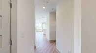 Located in Franklin, TN, this thoughtfully designed 2-bedroom, 2-bathroom residence offers a clean, modern aesthetic throughout its single-floor layout. Light wood-tone flooring flows seamlessly through every room, complemented by crisp white walls and matte black hardware accents that add a contemporary edge.

The open-concept kitchen and living area serves as the heart of the home. The kitchen features white shaker-style cabinetry extending to the ceiling for generous storage, a white quartz island with an undermount sink, a white subway tile backsplash, and stainless steel appliances including a French door refrigerator, range, and built-in microwave.

The living room is bright and airy, with multiple windows fitted with blinds, a ceiling fan, and a door providing access to an outdoor balcony with views of the surrounding greenery.

Both bedrooms are comfortably sized, each featuring ceiling fans, large windows with natural light, and easy access to dedicated closets. The primary bedroom offers a generous footprint and a well-appointed en-suite bathroom.

Both bathrooms maintain the home's modern palette, featuring white vanities, framed mirrors, matte black fixtures, and light wood flooring. A dedicated in-unit laundry area with a full-size washer and dryer adds everyday convenience. The hallway connects all spaces efficiently, completing this well-organized and stylish residence.