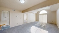 Located at 1112 Hidden Lakes Dr in Mishawaka, Indiana, this single-story residence offers a practical and comfortable layout with notable architectural details throughout. The living area is a standout space, featuring vaulted ceilings that rise to an elegant arched window, flooding the room with natural light. Vertical blinds frame a large sliding door that further enhances the bright, airy atmosphere, while soft gray carpeting extends throughout the main living and bedroom areas.

The kitchen is thoughtfully designed with a wraparound layout and a wood-trimmed peninsula that provides additional prep and dining space. Cream-toned cabinetry with warm wood accents lines the walls, complemented by a gas range, refrigerator, and ample counter space. The kitchen connects seamlessly to a carpeted hallway that leads to the private areas of the home.

The bedrooms are well-proportioned with neutral walls and carpeted floors; one features a pair of windows offering outdoor views. A dedicated hallway provides access to multiple closets and both bathrooms. One bathroom includes a walk-in shower stall with tile flooring and a single-sink vanity, while the second features a full soaking tub/shower combo with a matching vanity and tile floor. Overall, the space maintains a clean, neutral palette throughout.