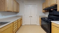 Located at 3138 S Crater Rd in Petersburg, Virginia, this single-floor residence offers a clean, functional layout designed for comfortable everyday living. The kitchen is well-equipped with light oak cabinetry, ample counter space featuring speckled laminate surfaces, and black appliances including a gas range and a side-by-side refrigerator with an in-door ice and water dispenser. A double pantry with classic panel doors provides generous storage, and tile flooring throughout the kitchen ensures easy maintenance. The bathroom is thoughtfully designed with accessibility in mind, featuring grab bars, a mirrored medicine cabinet, a vanity with an oak base, and tile flooring that complements the rest of the unit. The living areas are carpeted in a neutral tone, creating a warm and inviting atmosphere. Natural light flows in through windows fitted with blinds, and ceiling fans with integrated lighting fixtures are present throughout, promoting both comfort and air circulation. The overall color palette is light and neutral, with white walls and trim that keep the space feeling open and airy. This well-maintained residence offers a straightforward, practical floor plan suited for a variety of living arrangements.
