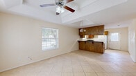 Located at 2108 Larkspur Ave in McAllen, Texas, this single-story, one-bedroom, one-bathroom home offers a thoughtfully arranged layout with comfortable living space throughout. Light-toned ceramic tile flooring runs consistently across all rooms, creating a clean and cohesive look.

The living and dining areas are bright and open, benefiting from multiple windows that allow generous natural light to fill the space. Tray ceilings with ceiling fans add architectural interest and help with air circulation — a practical feature in the South Texas climate. A pendant chandelier accents the dining area.

The kitchen is well-appointed with warm wood cabinetry extending to the upper walls, dark granite countertops, a breakfast bar peninsula, a double sink, and white appliances including a range and refrigerator. A window above the sink provides additional natural light.

The bedroom is a comfortable size, featuring its own tray ceiling with a ceiling fan, a window with natural light, and direct access to a dedicated walk-in closet. The closet is generously sized with built-in shelving and hanging rods offering ample storage.

The bathroom includes a full tub-shower combo with clean white finishes and tile flooring. A hallway connects the main areas of the home, contributing to an efficient and functional floor plan overall.