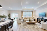 Located at 4100 Wheaton Pl in Howell, Michigan, this single-story, 2-bedroom, 2-bathroom home offers a thoughtfully designed open floor plan with generous living space. Light wood-tone flooring flows throughout, complementing the neutral palette and creating a cohesive, modern aesthetic.

The heart of the home is the open-concept kitchen, dining, and living area. The kitchen features taupe shaker cabinetry, stainless steel appliances, white countertops, a subway tile backsplash, and a central island with seating — illuminated by stylish pendant lighting. The adjacent dining area transitions seamlessly into the spacious living room, which showcases a tray ceiling and large windows with sliding door access to the outdoors, flooding the space with natural light.

The primary bedroom offers a comfortable retreat with well-sized windows, while the walk-in closet provides wire shelving and dedicated storage. A linen closet in the hallway adds further organization. The bathrooms are cleanly finished, with one featuring a full tub-shower combination framed by white subway tile.

A well-connected hallway with recessed lighting links all rooms efficiently. The attached garage is spacious, with a concrete floor, opener system, and attic access panel. A dedicated utility room rounds out the functional layout of this move-in-ready Howell home.