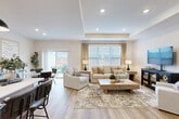 Located at 4100 Wheaton Pl in Howell, Michigan, this single-story, 2-bedroom, 2-bathroom home offers a thoughtfully designed open floor plan with generous living space. Light wood-tone flooring flows throughout, complementing the neutral palette and creating a cohesive, modern aesthetic.

The heart of the home is the open-concept kitchen, dining, and living area. The kitchen features taupe shaker cabinetry, stainless steel appliances, white countertops, a subway tile backsplash, and a central island with seating — illuminated by stylish pendant lighting. The adjacent dining area transitions seamlessly into the spacious living room, which showcases a tray ceiling and large windows with sliding door access to the outdoors, flooding the space with natural light.

The primary bedroom offers a comfortable retreat with well-sized windows, while the walk-in closet provides wire shelving and dedicated storage. A linen closet in the hallway adds further organization. The bathrooms are cleanly finished, with one featuring a full tub-shower combination framed by white subway tile.

A well-connected hallway with recessed lighting links all rooms efficiently. The attached garage is spacious, with a concrete floor, opener system, and attic access panel. A dedicated utility room rounds out the functional layout of this move-in-ready Howell home.