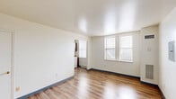 Located at 1623 W Chelten Ave in Philadelphia's 19126 zip code, this three-bedroom, one-bathroom unit offers a practical and straightforward layout across a single floor. Light-toned walls and warm hardwood-style laminate flooring run throughout, creating a clean, cohesive look in every room.

The main living area is bright and open, with multiple windows allowing natural light to fill the space. It connects seamlessly to the kitchen, which features rich dark-brown cabinetry — both upper and lower — paired with a matching countertop, a single-basin sink, and a white gas range, providing ample storage and functionality.

The three bedrooms are well-proportioned, each finished with the same laminate flooring and neutral walls. The primary bedroom offers a comfortable footprint with windows that bring in outside light. One of the additional bedrooms includes a dedicated closet, adding practical storage. A hallway connects the rooms and provides easy flow throughout the unit.

The bathroom is tiled in classic light-pink subway tile from floor to ceiling in the tub surround, with a full soaking tub and a window for natural ventilation. The overall ambiance of the unit is clean, functional, and move-in ready, suited for those seeking straightforward city living in Philadelphia.