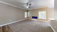 Located in Elk Grove, CA, this single-story, 4-bedroom, 2-bathroom home offers a well-designed layout with modern finishes throughout. The open living room is a standout, featuring a sleek wall-mounted electric fireplace, a ceiling fan with light, crown molding, and plush carpeting. Multiple windows allow natural light to fill the space, creating a bright and welcoming ambiance. The kitchen is outfitted with crisp white shaker cabinets, a subway tile backsplash, light wood-style flooring, and stainless steel appliances including a refrigerator, range, and built-in microwave. A convenient pass-through counter connects the kitchen to the living area. The four bedrooms are carpeted and equipped with ceiling fans; each features closet storage, with one bedroom showcasing mirrored sliding closet doors. The hallway includes additional mirrored closet storage, adding depth to the space. The two bathrooms are finished with wood-style flooring and clean white fixtures. The primary bathroom offers a vanity with white countertops and ample cabinetry, while the secondary bathroom includes a full tub-shower combo. Neutral warm-gray tones are carried consistently throughout, lending a cohesive and modern feel to the entire home.