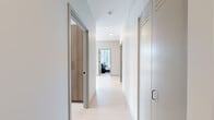 Located in Chicago's vibrant River North neighborhood, this modern 2-bedroom, 2-bathroom residence offers a thoughtfully designed open layout bathed in natural light. Floor-to-ceiling windows in the living room and kitchen frame sweeping city skyline views, creating a bright and airy atmosphere throughout. The kitchen is a standout feature, showcasing warm wood cabinetry, a bold blue subway tile backsplash, dark stone countertops, a center island with bar seating, and track lighting — all complemented by views of the Chicago skyline. The open-plan living area flows seamlessly from the kitchen, with large windows flooding the space with sunlight. The primary bedroom is generously sized, offering direct skyline views through expansive floor-to-ceiling glazing. The en-suite primary bathroom features marble-style tile flooring, a sleek dual-sink vanity with slate-toned cabinetry, and a walk-in glass-enclosed shower. The second bedroom is well-proportioned and connects to a second full bathroom finished with dark stone tile, a wood-toned vanity, and a soaking tub. A clean, light-toned hallway with modern sliding doors connects the rooms, completing this refined urban residence.