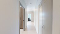 Located in Chicago's vibrant River North neighborhood, this modern 2-bedroom, 2-bathroom residence offers a thoughtfully designed open layout bathed in natural light. Floor-to-ceiling windows in the living room and kitchen frame sweeping city skyline views, creating a bright and airy atmosphere throughout. The kitchen is a standout feature, showcasing warm wood cabinetry, a bold blue subway tile backsplash, dark stone countertops, a center island with bar seating, and track lighting — all complemented by views of the Chicago skyline. The open-plan living area flows seamlessly from the kitchen, with large windows flooding the space with sunlight. The primary bedroom is generously sized, offering direct skyline views through expansive floor-to-ceiling glazing. The en-suite primary bathroom features marble-style tile flooring, a sleek dual-sink vanity with slate-toned cabinetry, and a walk-in glass-enclosed shower. The second bedroom is well-proportioned and connects to a second full bathroom finished with dark stone tile, a wood-toned vanity, and a soaking tub. A clean, light-toned hallway with modern sliding doors connects the rooms, completing this refined urban residence.