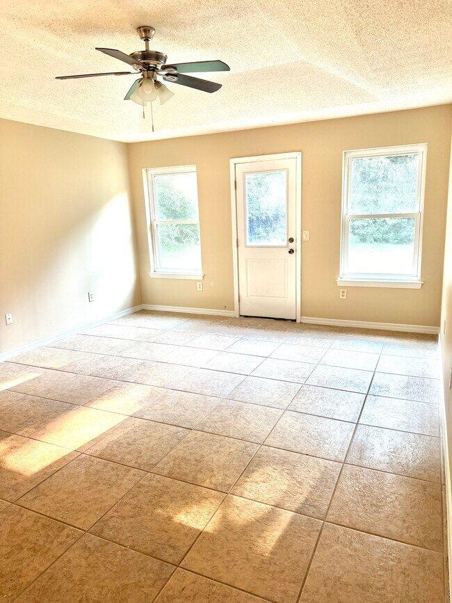 Dormitorio principal con suelo de baldosas y abundante luz natural gracias a sus múltiples ventanas. - 6281 Hunters Ridge Dr