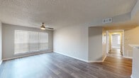 This single-story home at 1544 W Tenth St in North Little Rock, Arkansas offers a well-organized layout with a comfortable, functional design throughout. The living areas feature wood-look plank flooring in a neutral gray tone, contributing to a clean and modern aesthetic. Ceiling fans with integrated lighting are present in multiple rooms, providing both airflow and ambient illumination.

The galley-style kitchen is a practical highlight, fitted with gray cabinetry, white countertops, a stainless steel sink with a brushed gold faucet, and a full suite of appliances including a refrigerator, electric range, built-in microwave, and dishwasher. Wood-look flooring continues seamlessly through this space.

The bedrooms are carpeted in soft gray tones and include generous natural light from horizontal-blind-fitted windows. A spacious walk-in closet with wire shelving offers notable storage capacity. Two bathrooms serve the home—one featuring a gray vanity with a tub/shower combination, and another with a wide vanity, wood-look flooring, and ample counter space. Textured ceilings appear throughout, and neutral wall tones create a cohesive, move-in-ready atmosphere across all rooms.