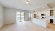 Located at 2330 Union St, Unit 271 in Fort Myers, Florida, this well-appointed 3-bedroom, 3-bathroom unit offers a thoughtfully designed single-floor layout with a clean, contemporary aesthetic throughout. The open-concept kitchen and living area serves as the heart of the home, featuring white shaker cabinetry with gold hardware, a marble-style tile backsplash, stainless steel appliances including a refrigerator, range, and microwave, a beverage cooler, and a large central island with a quartz countertop and undermount sink — ideal for both cooking and entertaining. Light-toned flooring flows seamlessly across the main living areas, enhancing the bright, airy feel of the space. Each of the three bedrooms is well-sized, with the spacious primary bedroom offering natural light through slatted blinds and a ceiling fan. The primary bathroom is a standout, showcasing a dual-sink vanity with gold fixtures, LED-backlit mirrors, and a glass-enclosed walk-in shower with floor-to-ceiling tile. Secondary bathrooms feature tub-shower combinations with matching gold accents and tile surrounds. A dedicated laundry room with full-size washer and dryer adds everyday convenience. The unit also includes hallway connections and a closet, completing a functional and stylish living environment.
