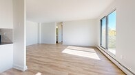 Located at 498 Queens Ave in London, Ontario, this well-appointed 2-bedroom, 1-bathroom unit offers a bright and clean living environment across a single floor. Light-toned hardwood flooring runs consistently throughout the space, creating a cohesive and airy aesthetic complemented by crisp white walls and trim.

The entrance leads into a central hallway connecting the key living areas. The kitchen is efficiently designed in a galley layout, featuring white cabinetry, a subway tile backsplash, dark countertops, and a full suite of stainless steel appliances including a refrigerator, stove, and microwave. Adjacent to the kitchen, the dining area transitions naturally into the living room, which benefits from large windows that flood the space with natural light and provide outdoor views of surrounding greenery.

The primary bedroom is generously sized, offering ample space and a window with pleasant outdoor views. The second bedroom also features a window with natural light and baseboard heating. Both bedrooms include closet access, with four closets total found throughout the unit. The bathroom is finished with large-format floor tiles, a white subway tile tub surround, a soaker tub, and a white vanity. A private balcony adds desirable outdoor access to this well-rounded unit.