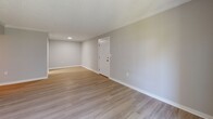 Located at 10531 3rd St N in Saint Petersburg, FL, this one-bedroom, one-bathroom unit offers a thoughtfully updated interior across a single floor. Light wood-style luxury vinyl flooring runs throughout the living spaces, complemented by soft neutral gray walls, crisp white baseboards, and crown molding that lend a clean, cohesive aesthetic. The living room is a comfortable, open area featuring a sliding glass door that invites natural light and provides views of the surrounding greenery. A textured ceiling adds subtle character throughout the main living spaces. The kitchen is well-appointed with white shaker-style cabinetry, quartz countertops, a stainless steel undermount sink with a brushed nickel faucet, and a neutral tile backsplash — delivering both style and functionality. The bedroom is a well-proportioned retreat with a window fitted with blinds for natural light and privacy, plus access to a dedicated closet. The bathroom features a tub-shower combination with elegant marble-look tile surround, brushed gold fixtures, pebble tile flooring, and a clean, spa-inspired finish. A hallway connects the rooms efficiently, completing this well-organized, move-in-ready residence.