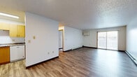 Located at 3302 31st Ave S in Fargo, ND, this single-floor residence offers three bedrooms and two bathrooms within a functional and well-maintained layout. The open living area features warm wood-look laminate flooring, crisp white walls, a textured ceiling, and a sliding glass door that invites natural light. A wall-mounted AC unit and baseboard heating ensure year-round comfort. The living space flows toward the kitchen, which is outfitted with honey-toned wood cabinetry, granite-style countertops, a double stainless steel sink, and a dishwasher — offering ample storage and prep space. The three bedrooms are carpeted for comfort, each featuring windows with blinds that bring in natural light, wood-trimmed closets, and baseboard heating. The primary bedroom is a generous size, providing a comfortable personal retreat. Both bathrooms are clean and practical; one features a wood-vanity with granite-style countertop, a large mirror, and a full tub/shower combination. A hallway connects the private quarters to the main living areas, creating a clear and logical flow throughout the home. The overall ambiance is clean, neutral, and move-in ready.
