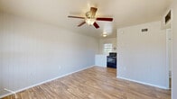 Located at 1834 Wilmington Hwy in Jacksonville, NC, this single-floor, 2-bedroom, 1-bathroom home offers a practical and well-organized layout. The open living area features durable wood-look laminate flooring and a ceiling fan with a light fixture, creating a bright and airy atmosphere. The space flows seamlessly into the kitchen and dining area, which is equipped with a black range and a window that brings in natural light. The front entry area continues the wood-look flooring and includes access to a closet, with a window overlooking the outdoors. Both bedrooms are finished with plush carpet flooring and ceiling fans. The primary bedroom offers generous proportions, a closet with bifold doors, and multiple windows that invite natural light and outdoor views. The second bedroom also features windows with outdoor views and its own closet. The home includes a total of four closets throughout, providing excellent storage. The full bathroom is finished in clean white tones, featuring a single vanity with mirror, a tub-shower combination, and wood-look tile flooring. A connecting hallway ties all rooms together in a cohesive, easy-to-navigate floor plan.