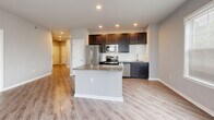 Located at 91 York Rd in Willow Grove, PA, this well-appointed single-floor residence offers three bedrooms and two full bathrooms thoughtfully laid out for comfortable living. The kitchen serves as the heart of the home, showcasing rich dark cabinetry, a white subway tile backsplash, stainless steel appliances, and a granite-topped center island that flows seamlessly into the open living area. Light wood-look vinyl plank flooring runs throughout the main areas, lending a clean, contemporary feel.

The primary bedroom is generously sized, featuring plush carpeting and a stylish barn door that opens to a walk-in closet equipped with wire shelving and hanging rods for ample storage. The additional bedrooms are carpeted and bright, with natural light streaming through large windows with blinds. The hallway connects the rooms efficiently, accented by recessed lighting and louvered closet doors.

Both bathrooms are well-finished; one features a soaking tub/shower combo with tile flooring, while the other includes a dual-sink vanity with granite countertops, dark cabinetry, and a large mirror. Neutral gray tones throughout the space create a calm, cohesive atmosphere that is move-in ready and easy to personalize.
