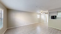 Located at 5205 Fairbanks Dr in El Paso, TX, this single-floor unit offers a practical and well-appointed layout. The open-concept kitchen and living area forms the heart of the space, finished with light-toned luxury vinyl plank flooring that runs throughout, creating a clean and cohesive look. Neutral warm-gray walls and white baseboards contribute to a bright, airy atmosphere. The living area benefits from multiple windows fitted with blinds, allowing natural light to filter in, and is equipped with a ceiling fan for added comfort. A textured popcorn ceiling adds a classic touch overhead.

The kitchen is efficiently organized in a galley-style configuration, featuring gray cabinetry, white countertops, a stainless steel refrigerator, a range, and a dishwasher. A pass-through counter connects the kitchen to the living area, enhancing the open feel of the shared space.

The bathroom is clean and functional, showcasing a vanity with a white countertop, an undermount sink, gray cabinetry, and a large mirror with overhead lighting. An adjacent closet provides convenient storage directly off the bathroom. The overall design of this unit prioritizes smart use of space, clean finishes, and a neutral palette suited to a variety of lifestyles.