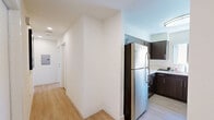 Located in Granada Hills, CA, this thoughtfully designed one-bedroom, one-bathroom unit offers a modern and functional living experience within a compact, single-floor layout. Light wood flooring runs throughout, lending warmth and continuity to every room.

The kitchen is a standout feature, outfitted with rich dark-brown cabinetry, stainless steel appliances including a full-size refrigerator, gas range, dishwasher, and microwave, plus bright white countertops that provide a clean contrast. Ample upper and lower cabinet storage ensures excellent functionality. A second kitchenette area within the bedroom provides additional convenience, fitted with warm wood cabinetry and its own countertop workspace.

The bedroom is efficiently arranged and includes a Murphy bed, a compact sofa, and a fold-down desk — making excellent use of the available space. A window with vertical blinds allows natural light to fill the room. A dedicated closet provides organized storage.

The bathroom is clean and contemporary, featuring a combined tub and shower enclosed by sliding glass doors, a wood-toned vanity, and recessed lighting overhead.

A connecting hallway ties the spaces together seamlessly, contributing to the unit's smart, streamlined flow. Overall, the design prioritizes modern aesthetics and practical living.
