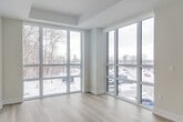 This thoughtfully designed one-bedroom, one-bathroom unit at 41 Johnson Street in Barrie, Ontario offers a bright and contemporary living experience. The open-concept layout seamlessly connects the kitchen, dining, and living areas, all finished with light hardwood flooring and a neutral, modern palette throughout.

The kitchen is well-appointed with sleek grey and white cabinetry, a white subway tile backsplash, stainless steel appliances including a French-door refrigerator, built-in dishwasher, and microwave, plus a central island with bar seating — ideal for everyday dining or entertaining. The living and dining area is bathed in natural light from large windows, creating an airy, welcoming atmosphere.

The bedroom is a serene retreat featuring a spacious sliding-door closet, a large window overlooking the outdoor balcony, and a calm, neutral finish. The bathroom is clean and functional, with full tub and shower, white tile surround, and light tile flooring. A bold, dark-finish front entry door adds a modern contrast at the unit's entrance, alongside a mirrored closet for added storage. The private balcony extends the living space outdoors with pleasant exterior views.