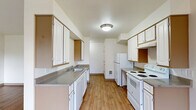 Located at 1473 N Goerig St in Woodland, WA, this single-story, one-bedroom, one-bathroom home offers a well-organized and functional layout across a comfortable footprint. The entrance leads into a bright, open living area featuring warm hardwood-style flooring and a sliding glass door fitted with vertical blinds that floods the space with natural light and provides direct access to a private outdoor area with green views.

The galley-style kitchen and dining area are thoughtfully designed, featuring white cabinetry with ample upper and lower storage, grey laminate countertops, a double sink, a white electric coil range with overhead cabinetry, and a full-size refrigerator. The kitchen flows openly toward the dining area, which is outfitted with a ceiling fan and a window overlooking the outdoors.

The bedroom is a comfortable, well-proportioned room carpeted for warmth, with a large window dressed in vertical blinds that brings in natural light and outdoor views. A dedicated closet adds practical storage. The bathroom is clean and simply appointed, featuring a full soaking tub with shower, a pedestal sink, a mirrored medicine cabinet with shelving, and hardwood-style flooring. A dedicated laundry area completes this home's practical amenities.
