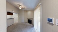 This single-story residence features 2 bedrooms, 2 bathrooms, and a well-organized layout designed to maximize functionality. The living room serves as the central gathering space, highlighted by a tile-surround fireplace and large sliding glass doors dressed with vertical blinds that invite natural light into the room. Carpet flooring and a textured ceiling with a ceiling light fixture complete the comfortable atmosphere.

The kitchen is a galley-style space featuring dark espresso cabinetry, light countertops, a mosaic tile backsplash, and wood-look flooring. Black appliances, including a range and refrigerator, are paired with a stainless steel sink, and the kitchen opens to the living area via a pass-through counter with overhead cabinetry.

The primary bedroom is a well-proportioned retreat with carpet flooring, neutral walls, a textured ceiling, and access to a dedicated closet. The second bedroom is similarly finished, featuring a window with blinds that allows for natural light. Both bathrooms are equipped with a tub-shower combination, floor-to-ceiling tile surround with a decorative mosaic border accent, and chrome fixtures. The unit also includes two closets for ample storage throughout.