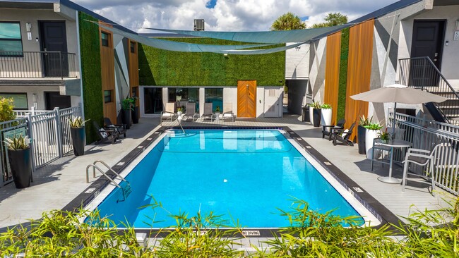 Disfrute de un refrescante descanso en nuestra hermosa área de piscina. Con un diseño elegante, cómodos asientos tipo lounge y un paisaje vibrante, es su lugar ideal para relajarse o disfrutar del sol de Florida. - Elon Winter Park