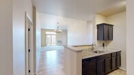 Located at 3327 N Casaloma Dr in Appleton, Wisconsin, this well-appointed 2-bedroom, 3-bathroom single-story residence offers a thoughtfully designed layout across a comfortable footprint. The open-concept living and kitchen area serves as the heart of the home, where wood-style flooring flows underfoot and an elegant chandelier anchors the space. The kitchen is outfitted with dark espresso cabinetry, granite countertops, a breakfast bar peninsula with an undermount sink, and full Whirlpool appliances including a refrigerator, range, and dishwasher. A sliding glass door in the living area provides outdoor access and fills the space with natural light. The primary bedroom is generously sized, featuring soft carpeting, a chandelier light fixture, a window with outdoor views, and access to a spacious walk-in closet with wire shelving. The second bedroom also offers carpeted flooring, a chandelier, and a large window. Three bathrooms serve the residence, with at least one featuring wood-look tile flooring, a full soaking tub and shower combo, granite vanity, and a window for natural light. A dedicated laundry room houses a full-size washer and dryer with overhead dark cabinetry for additional storage. Two closets provide ample storage throughout the home.