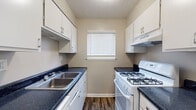Located at 2039 Bent Creek Way SW in Atlanta, Georgia, this two-story home offers a practical and well-organized layout across both floors. The main level features durable wood-look flooring throughout the open living area, which flows seamlessly toward the staircase and entry. A convenient half bath with a pedestal sink is also situated on the main floor, ideal for guests. The galley-style kitchen is efficiently designed with dark granite-look countertops, white cabinetry, a stainless steel sink, and a gas range, complemented by a window that brings in natural light. A carpeted staircase with a handrail leads to the upper level, where the bedrooms are located. Each bedroom is carpeted and features neutral wall tones and windows with blinds that allow for natural light. The primary bedroom stands out with generous double closets equipped with built-in shelving and hanging rods, providing ample storage. A full bathroom on the upper level includes a single-sink vanity with dark countertops, white cabinetry, a combined tub and shower unit, and wood-look flooring. The home's neutral color palette and practical finishes create a clean, move-in-ready environment throughout.