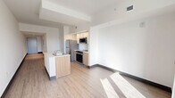 Located at 224 23rd St in Miami Beach, Florida, this modern unit on the first floor offers a clean, contemporary design with a thoughtfully organized layout. Light wood-tone flooring flows throughout, complementing the crisp white walls and creating a bright, cohesive aesthetic.

A long entryway corridor leads into the open-plan living and kitchen area, which serves as the heart of the space. The kitchen is equipped with stainless steel appliances including a refrigerator, electric range, and built-in microwave. Warm wood cabinetry pairs with white upper cabinets and a white quartz countertop island featuring an undermount sink — offering both prep space and a casual dining option. Recessed under-cabinet lighting adds a polished finish.

The living area benefits from generous natural light, enhanced by a set of glass French doors that open onto a private balcony with open city views — a standout feature of this unit. The bedroom is a well-proportioned, sunlit room with direct balcony access.

The bathroom features a white subway tile tub-and-shower surround, a wood-toned vanity with a white quartz countertop, an undermount sink, and a large frameless mirror. Clean lines and neutral finishes define the space throughout, reflecting a modern sensibility well-suited to the Miami Beach setting.