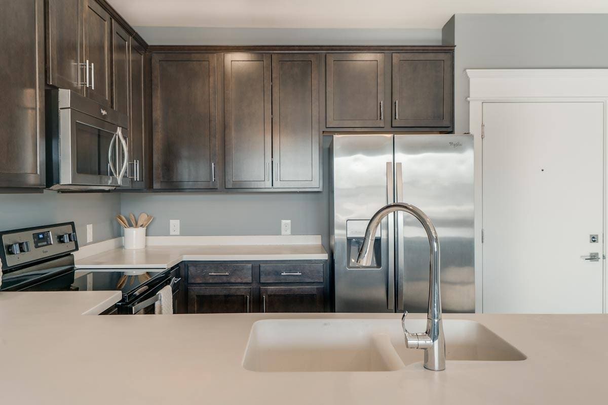 A modern kitchen with rich cabinetry and sleek finishes makes every meal feel like an experience. - The Helen