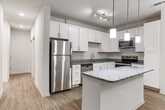 Located at 158 S Davis Rd in LaGrange, Georgia, this single-floor residence offers a clean, modern interior with a cohesive design throughout. The kitchen serves as a focal point of the living space, showcasing white shaker-style cabinetry, granite countertops, and a full suite of stainless steel appliances including a refrigerator, dishwasher, microwave, and range. A peninsula with a granite overhang provides additional prep and dining space, while pendant lighting and track lighting overhead create a bright, functional atmosphere. Wood-look flooring extends through the kitchen and main living areas, lending warmth and continuity.

The bedrooms are carpeted and generously sized, each featuring windows with blinds that allow ample natural light. One bedroom includes a walk-in closet with built-in shelving, offering practical storage. An in-unit laundry area is also visible from the bedroom hallway, adding everyday convenience.

The bathrooms mirror the kitchen's aesthetic, with white vanity cabinetry, granite countertops, undermount sinks, and wood-look flooring. Both bathrooms are well-lit and cleanly finished. Overall, the space presents a consistent, contemporary palette of neutral tones, modern fixtures, and quality finishes throughout.