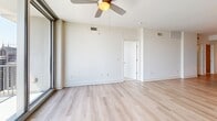 Located in the heart of uptown Charlotte, this well-appointed 3-bedroom, 3-bathroom residence offers a thoughtfully designed single-floor layout with a clean, modern aesthetic throughout. The open-concept kitchen and living area serves as the centerpiece of the home, featuring rich cherry wood cabinetry, gleaming granite countertops, a large center island, stainless steel appliances, and track lighting overhead — a highly functional space ideal for cooking and entertaining. The living area is finished with light hardwood flooring and a ceiling fan, and opens directly onto a private balcony through floor-to-ceiling glass sliding doors, offering sweeping views of the Charlotte skyline. Each of the three bedrooms is finished with plush carpeting and ceiling fans, providing a comfortable retreat. The generously sized primary bedroom includes a walk-in closet with built-in shelving and wire rack storage. The bathrooms are finished with large-format tile flooring, granite-topped vanities with rich wood cabinetry, and frameless glass-enclosed walk-in showers. Two dedicated closets provide ample storage throughout the residence. The overall design balances warm wood tones with crisp white walls and neutral finishes, creating a bright and inviting living environment.