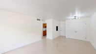Located at 5502 Washington St, Unit 208 in Hollywood, FL, this single-floor unit offers three bedrooms and two bathrooms within a well-organized layout. Gleaming large-format tile flooring runs consistently throughout the space, lending a clean, cohesive aesthetic to every room. The open living and dining area is filled with natural light courtesy of wide windows fitted with slatted blinds, creating a bright and airy atmosphere. A centrally visible entry point connects seamlessly to the living area, with the kitchen accessible just beyond. The galley-style kitchen is efficiently designed, featuring warm wood cabinetry, light countertops, a black undermount sink, and stainless steel appliances including a refrigerator and range—maximizing functionality within a compact footprint. The primary bedroom is generously proportioned and includes a dedicated closet with built-in shelving rods, offering ample storage. Additional bedrooms maintain the same neutral palette and tile flooring, each with access to closet space. Both bathrooms are outfitted with full tub-and-shower combinations framed by white tile surrounds and matte black showerheads, providing a clean, modern touch. Central air conditioning vents are present throughout, ensuring year-round comfort. The overall design is minimal and neutral, offering a versatile canvas well-suited to a variety of living arrangements.