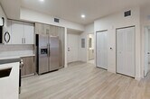 Located at 18412 Homestead Ave in Miami, FL, this well-designed unit offers three bedrooms, two bathrooms, and a kitchen across a single floor. The interior showcases a consistent modern aesthetic, with light wood-look flooring running throughout and a neutral, warm-white color palette that creates a bright, cohesive feel.

The kitchen is a standout feature, equipped with stainless steel appliances including a refrigerator with ice maker, range, and over-the-range microwave. Two-tone cabinetry pairs white upper cabinets with natural wood-finish lower cabinets, complemented by a white quartz countertop, subway tile backsplash, and a matte black faucet — all lending a contemporary, polished look.

Each of the three bedrooms is finished with the same light flooring and warm neutral walls, with windows fitted with roller shades that allow for natural light control. The primary bedroom offers a comfortable sense of space.

The two bathrooms are cleanly appointed with white vanities featuring undermount sinks, large mirrors with modern light bars, and matte black hardware accents. One bathroom includes a glass-enclosed shower, while the second features a tub/shower combination with tile surround.

A central hallway provides convenient access to all rooms, with closet storage nearby. Recessed lighting and updated fixtures throughout complete this move-in-ready Miami residence.