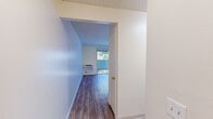 Located at 3975 Seven Trees Blvd in San Jose, CA, this one-bedroom, one-bathroom unit offers a practical and well-organized single-floor layout. The living room is bright and open, featuring light wood-style laminate flooring, neutral cream-toned walls, a textured ceiling, and a wall-mounted air conditioning unit. A sliding glass door leads directly to a private balcony, filling the space with natural light and providing views of surrounding greenery. A baseboard heater runs along the wall, providing supplemental warmth throughout the cooler months. The bedroom is a comfortable, contained space with its own window that frames an outdoor view, a baseboard heater, and the same wood-style flooring carried throughout the unit. A dedicated walk-in closet adjacent to the bedroom features wrap-around hanging rods, offering generous storage for a unit of this scale. The bathroom is clean and functional, equipped with a full tub and shower combo with white tile surround, a toilet, and a vanity with an integrated sink, warm wood cabinetry, and a large mirror with overhead lighting. Throughout the unit, the consistent use of light flooring and neutral wall tones creates a cohesive, airy feel that maximizes the sense of space.