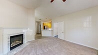 Located at 31 Lakemont Dr in Newnan, Georgia, this single-story home offers a well-organized floor plan across three bedrooms and two bathrooms. The living room serves as the central gathering space, featuring vaulted ceilings, a ceiling fan, and a tiled fireplace that adds a warm, inviting focal point. Soft carpet flooring flows throughout, while large windows allow natural light to brighten the interior.

The kitchen is open and functional, equipped with warm honey-toned wood cabinetry, stainless steel appliances including a gas range, dishwasher, microwave, and refrigerator, along with white countertops and a peninsula sink that connects seamlessly to the adjacent dining area. A chandelier overhead adds a subtle decorative touch to the dining space.

The generously sized primary bedroom features vaulted ceilings and a ceiling fan. Both bathrooms include wood vanities with white countertops, large mirrors with overhead lighting, and tub-shower combinations. One bathroom offers an additional separate shower stall and light wood-style flooring.

Secondary bedrooms are carpeted and neutrally finished. The attached garage provides additional utility space with an automatic opener. Throughout, the home maintains a clean, neutral palette suited for comfortable everyday living.