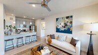 Located at 3232 N Garland Ave in Garland, TX, this thoughtfully designed one-bedroom, one-bathroom residence offers a clean, modern aesthetic across a single floor. The open-concept living and kitchen area serves as the heart of the home, where light wood-tone flooring, recessed lighting, and a contemporary ceiling fan create a bright and welcoming atmosphere. Large windows with slatted blinds invite natural light throughout, and a private exterior door provides convenient outdoor access directly from the living area.

The kitchen is equipped with stainless steel appliances — including a refrigerator, electric range, and built-in microwave — complemented by light gray shaker-style cabinetry and granite countertops. A peninsula with bar seating and elegant pendant lighting makes the kitchen ideal for both casual dining and entertaining.

A hallway leads to the private bedroom, which is comfortably proportioned and features windows that allow natural light to filter in, along with a ceiling fan. The room is served by a dedicated closet for storage. The full bathroom is accessed via the hallway and features a gray vanity with granite countertop, wood-tone flooring, and clean, neutral finishes. The overall design balances modern style with functional, efficient use of space.