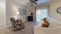 Located at 1000 Jensten Loop in Suffolk, Virginia, this single-floor residence offers a thoughtfully designed layout that balances functionality and comfort throughout its living spaces.

The kitchen is a standout feature, showcasing white shaker-style cabinetry paired with dark granite countertops and a full suite of stainless steel appliances, including a refrigerator, electric range, microwave, and dishwasher. Wood-look flooring runs through the kitchen, adding warmth and durability to the space. A breakfast bar provides additional counter space and a casual dining option.

The living room is bright and inviting, with plush carpeting, a ceiling fan, and a sliding glass door that opens to a balcony, allowing natural light to fill the room. The bedrooms are carpeted and feature windows that bring in additional natural light, creating a restful atmosphere.

The bathroom continues the consistent design aesthetic with granite countertops, shaker-style cabinetry, a large mirror, and wood-look flooring. A dedicated laundry room with a side-by-side washer and dryer and overhead shelving adds everyday convenience. The overall palette of neutral tones and quality finishes gives the space a clean, modern feel throughout.