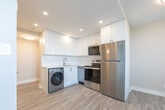 Located at 200 Jameson Ave in Toronto's vibrant Parkdale neighbourhood, this efficiently designed unit offers a thoughtfully updated interior across a single floor. The open-concept living area is finished with light-toned luxury vinyl plank flooring throughout, neutral warm-grey walls, and recessed pot lighting that keeps the space feeling bright and airy. A large window with balcony access floods the living area with natural light and provides open city views, complemented by a baseboard radiator for year-round comfort. The kitchen is a standout feature, showcasing high-gloss white cabinetry that extends to the ceiling, a clean white countertop with an undermount sink, stainless steel appliances including a refrigerator and dishwasher, and the added convenience of an in-unit washer. The entrance provides a welcoming transition into the living space, maintaining the clean, minimal aesthetic found throughout. The bathroom is elegantly appointed with a full soaker tub and a striking marble-effect wall surround in crisp white and grey tones, lending a refined, spa-like quality. A built-in closet in the living area offers practical storage. The overall ambiance is modern, clean, and move-in ready, making excellent use of every square foot.
