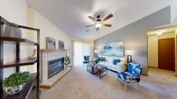 Located at 3307 Kennsington Court in Manhattan, Kansas, this single-floor residence offers a well-organized layout that balances comfort and functionality. The living room serves as the centerpiece of the home, distinguished by vaulted ceilings that lend a sense of openness and volume to the space. A tile-surround fireplace anchors one wall, while a ceiling fan provides year-round comfort. Sliding glass doors allow natural light to fill the room and provide access to the outdoors. Soft carpeting runs throughout the living areas, adding warmth underfoot.

The kitchen features warm oak cabinetry, stainless steel appliances including a refrigerator and range, and durable hard-surface flooring. It connects seamlessly to a dedicated dining area, which is highlighted by a pendant chandelier and additional hard-surface flooring, making it an ideal space for everyday meals or entertaining.

The two bedrooms are carpeted and each include ceiling fans and closets with sliding doors, offering practical storage. The bathroom is appointed with tile flooring, an oak vanity with ample counter space, and clean, neutral finishes. Throughout the home, wood-trimmed doors and neutral wall tones create a cohesive, understated aesthetic.