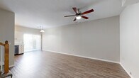 Located in Olathe, Kansas, this two-story, 2-bedroom, 3-bathroom home offers a well-organized layout spread evenly across two floors. The main level features an open-concept living, dining, and kitchen area bathed in natural light from a sliding glass door. The living room is finished with wood-style plank flooring and a ceiling fan with integrated lighting, creating a bright and comfortable gathering space. A pendant light fixture over the dining area adds a decorative touch. The kitchen stands out with crisp white shaker-style cabinetry, quartz countertops, a classic subway tile backsplash, stainless steel appliances including a refrigerator, range, microwave, and dishwasher, and durable hardwood-style flooring. The bathrooms are clean and functional, each featuring a tub-shower combination, white vanity with a cultured marble top, and wood-style flooring. Both bedrooms are located upstairs and are carpeted for comfort, each equipped with ceiling fans and generous closet space, including walk-in and sliding-door closets. A dedicated laundry area and a hallway with additional storage complete the interior. The neutral color palette throughout lends a move-in-ready feel to this efficiently designed home.