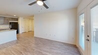 Located at 2036 S Hamilton St in Roanoke Rapids, NC, this well-appointed single-floor home offers three bedrooms, two bathrooms, and a thoughtfully designed open layout. The kitchen serves as a central hub of the home, featuring gray shaker-style cabinetry, granite-look countertops, a peninsula island with a stainless steel sink, and black appliances including a range and refrigerator. Recessed lighting illuminates the space, which flows naturally into the living area. The living room is bright and open, finished with durable hardwood-style flooring and a ceiling fan. Glass French doors lead to a private balcony, bringing in natural light and outdoor views. Each bedroom is carpeted with ceiling fans and ample natural light from windows. The primary bedroom includes a generous walk-in closet with wire shelving for organized storage. The bathrooms are finished with granite-look vanity countertops, dark wood cabinetry, and large mirrors. One bathroom features a full soaking tub and shower combination. Consistent hardwood-style flooring runs throughout the main living areas, complemented by clean white walls and modern fixtures, creating a cohesive and move-in-ready living environment.