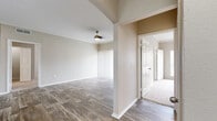 This single-story, 2-bedroom, 2-bathroom home offers a thoughtfully designed layout that maximizes functionality and comfort. The living and dining areas flow seamlessly together, featuring durable wood-look plank flooring, crown molding, and a ceiling fan. A sliding glass door floods the living room with natural light and provides convenient outdoor access. The kitchen is a standout feature, boasting white shaker cabinetry, a peninsula with an undermount sink, light countertops, and stainless steel appliances, including a range and microwave. Recessed and overhead lighting brightens the space efficiently. Hallways connect the living areas to the private bedroom wing, where both bedrooms are carpeted and include ceiling fans and windows with blinds for natural light and privacy. The generously sized primary bedroom includes its own closet and private access to a well-appointed en-suite bathroom featuring a white vanity with a rectangular undermount sink, framed mirror, and wood-look tile flooring. A second bathroom serves the additional bedroom and guests. Two closets provide ample storage throughout. The neutral color palette, consistent finishes, and practical design make this a comfortable and move-in ready home.