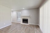 Located at Legacy Apartments in Plano, Texas, this single-story, two-bedroom, two-bathroom apartment offers a well-organized and functional layout. The living room serves as the heart of the home, featuring light wood-look flooring, neutral gray walls, a textured ceiling, and a tile-surround wood-burning fireplace with a white mantel — a standout focal point that adds warmth and character. Natural light filters in through blinds-fitted windows, enhancing the open feel of the space.

The kitchen is equipped with dark cabinetry, granite-look countertops, a double-basin sink, and a black dishwasher, complemented by a separate pantry for additional storage. A dedicated dining area and in-unit laundry room add to the practicality of the floor plan.

Both bedrooms feature plush carpeting and ceiling fans, with the primary bedroom offering a comfortable, well-proportioned retreat. Multiple closets — five in total — provide generous storage throughout. The bathrooms are clean and functional, each featuring a tub-shower combination with white tile surround and wood-look tile flooring. The overall aesthetic is neutral and move-in ready, making this a practical and comfortable residence in the Plano community.