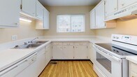 Located at 6880 Lefferson Rd in Middletown, Ohio, this two-story home offers a practical and well-organized layout across both levels. The main floor features a spacious living area finished with wall-to-wall carpeting, a large window, and a sliding glass door that fills the room with natural light and provides direct outdoor access. A staircase with a built-in closet for additional storage connects the main level to the upper floor. The kitchen is thoughtfully designed in a U-shaped configuration, offering ample white cabinetry, generous counter space, and light wood-style flooring. A window above the counter area brings in natural light, and the kitchen includes a sink, dishwasher, and range. A full bathroom on one of the levels features tile flooring, a shower-tub combination, toilet, and a wood-toned vanity. The bedrooms are carpeted and well-sized, with one featuring vaulted ceilings and dual closets for generous storage. Additional bedrooms include standard closets and windows that provide natural light. Throughout the home, warm neutral tones on the walls and trim create a clean, cohesive aesthetic suited for comfortable everyday living.