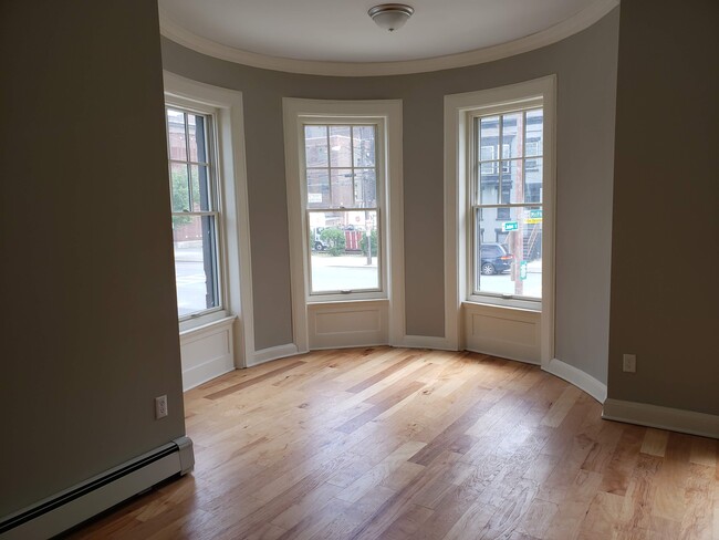 Large living room with hardwood flooring. Living room has four windows. - 2 Judson St