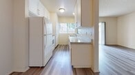 Located at 18944 Vickie Ave, Unit 225 in Cerritos, CA, this 790-square-foot, single-story apartment offers a practical and comfortable layout across two bedrooms, one bathroom, a combined kitchen and living room, and a hallway. The living room features wood-style laminate flooring, a wall-mounted AC unit, and a sliding glass door that opens to a private balcony, allowing natural light to fill the space. The galley-style kitchen is equipped with white cabinetry, granite-look countertops, a refrigerator, electric range, built-in microwave, and a window that provides additional natural light. It connects seamlessly to the hallway leading to the rest of the unit. The primary bedroom spans 250 square feet and includes plush carpeting, a ceiling fan, a window with outdoor views, and a mirrored sliding-door closet. The second bedroom also features carpet flooring, a ceiling fan, and a bright window. Both bedrooms share a full bathroom appointed with wood-style flooring, a white vanity with a mirror, and a shower. Throughout the unit, textured ceilings and neutral wall tones contribute to a clean, move-in-ready aesthetic.