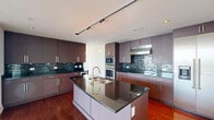 Located in the heart of uptown Charlotte at 215 N Pine St, this refined three-bedroom, four-bathroom high-rise residence offers an exceptional blend of modern design and urban living. The open-concept living room is anchored by dramatic floor-to-ceiling glass windows that flood the space with natural light and frame sweeping panoramic views of the Charlotte skyline and beyond. Rich hardwood flooring flows throughout the main living areas, complementing the clean, contemporary aesthetic.

The chef's kitchen is outfitted with dark granite countertops, sleek flat-front cabinetry, a mosaic tile backsplash, stainless steel double wall ovens, a built-in wine cooler, and ample storage — ideal for both everyday cooking and entertaining.

The generously sized primary bedroom features plush carpet, a ceiling fan, and floor-to-ceiling windows with direct access to a balcony overlooking the city skyline. It is complemented by a luxurious en-suite bathroom complete with a frameless glass walk-in shower, a soaking tub, and travertine tile finishes. Additional bedrooms are well-proportioned with large windows and ceiling fans. Secondary bathrooms feature granite vanities, wood cabinetry, and glass-enclosed showers. Four custom closets with built-in shelving and a dedicated laundry room with a stacked washer and dryer round out this thoughtfully designed residence.