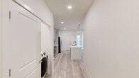 Located at 210 Brunswick Pl in Myrtle Beach, SC, this well-appointed single-floor home offers three bedrooms, two bathrooms, and a thoughtfully designed open layout. The kitchen serves as a central highlight, featuring soft gray shaker-style cabinetry, white quartz countertops, a subway tile backsplash, stainless steel appliances including a range, microwave, and French door refrigerator, and a center island with pendant lighting above — ideal for both cooking and casual dining. Light wood-look flooring runs throughout the main living areas, lending a clean and contemporary feel.

The spacious primary bedroom includes light wood flooring, recessed lighting, a ceiling fan, and access to a private outdoor area through a glass door, with views of surrounding greenery. Its walk-in closet is outfitted with wire shelving for organized storage. The en suite bathroom features a glass-enclosed walk-in shower with white tile surround and brushed gold hardware. The two additional bedrooms are carpeted and naturally lit by double windows, each equipped with ceiling fans. The second bathroom offers a full tub/shower combo with a white surround and brushed gold fixtures. Throughout, the home presents a bright, neutral palette that creates a clean and inviting atmosphere.