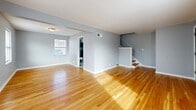 This two-story home in Kansas City, Missouri offers a practical and well-organized layout spread across two floors of nearly equal size. The main floor features a bright, open living room and an adjoining dining area, both finished with warm hardwood flooring that flows throughout the space. Natural light pours in through multiple windows, highlighting the clean light-gray walls and white trim. The kitchen is outfitted with white cabinetry, a mosaic tile backsplash, marble-style tile flooring, and black appliances including a gas range, over-the-range microwave, dishwasher, and refrigerator. A staircase leads to the upper floor, where two bedrooms are located. The spacious primary bedroom offers generous square footage, hardwood floors, and a large closet. The second bedroom is comfortable and well-lit with a window offering neighborhood views. The full bathroom is conveniently positioned on the upper floor. Notably, the home includes an impressive six closets total, providing exceptional storage throughout. The consistent hardwood flooring, neutral color palette, and clean architectural lines give the entire home a cohesive and move-in-ready feel.