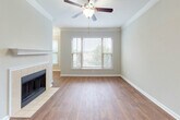 Located at 50 Paces Pkwy in Woodstock, Georgia, this single-floor residence offers a well-organized layout with a thoughtful mix of finishes and functional spaces throughout.

The living area is a standout, featuring warm wood-style flooring, crown molding, a ceiling fan, and a tile-surround fireplace that serves as a natural focal point. A large window invites abundant natural light and provides views of the surrounding community, while built-in shelving adds practical storage and character.

The galley-style kitchen is efficiently designed with dark espresso cabinetry, granite-style countertops, a tile backsplash, and stainless steel appliances including a refrigerator, range, and microwave. The wood-style flooring continues here, maintaining visual cohesion throughout the main areas.

The bedroom offers plush carpeting, a window with outdoor views, and a ceiling light fixture, creating a comfortable and quiet retreat. Additional closet space is also present.

The bathroom is well-appointed with rich dark wood cabinetry, a white countertop vanity, a large framed mirror, and a shower/tub combination featuring decorative tile accents. Wood-style flooring carries through here as well, tying the space together with a consistent, polished aesthetic throughout this Woodstock home.